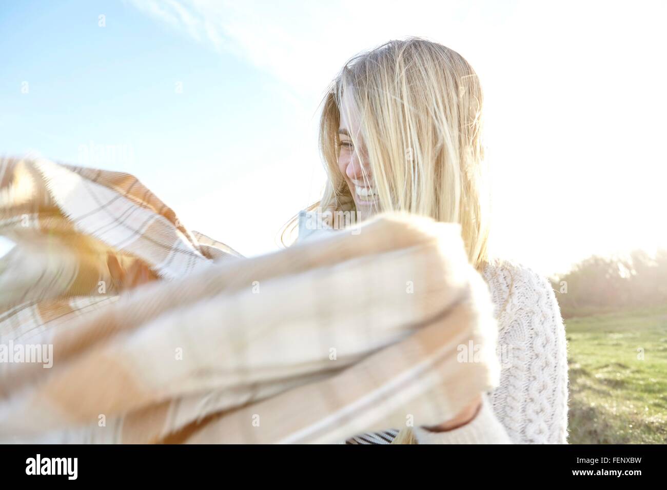 Giovane donna alle prese con il vento bruciato sciarpa Foto Stock