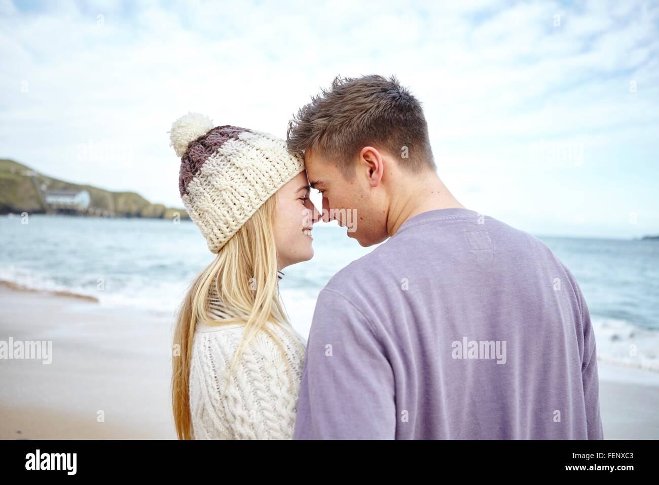 Romantico coppia giovane faccia a faccia sulla spiaggia, Constantine Bay, Cornwall, Regno Unito Foto Stock