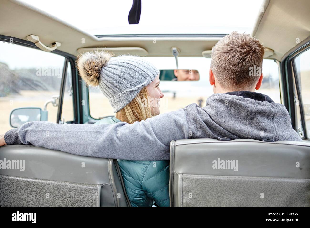 Vista posteriore della coppia giovane in auto alla spiaggia Foto Stock