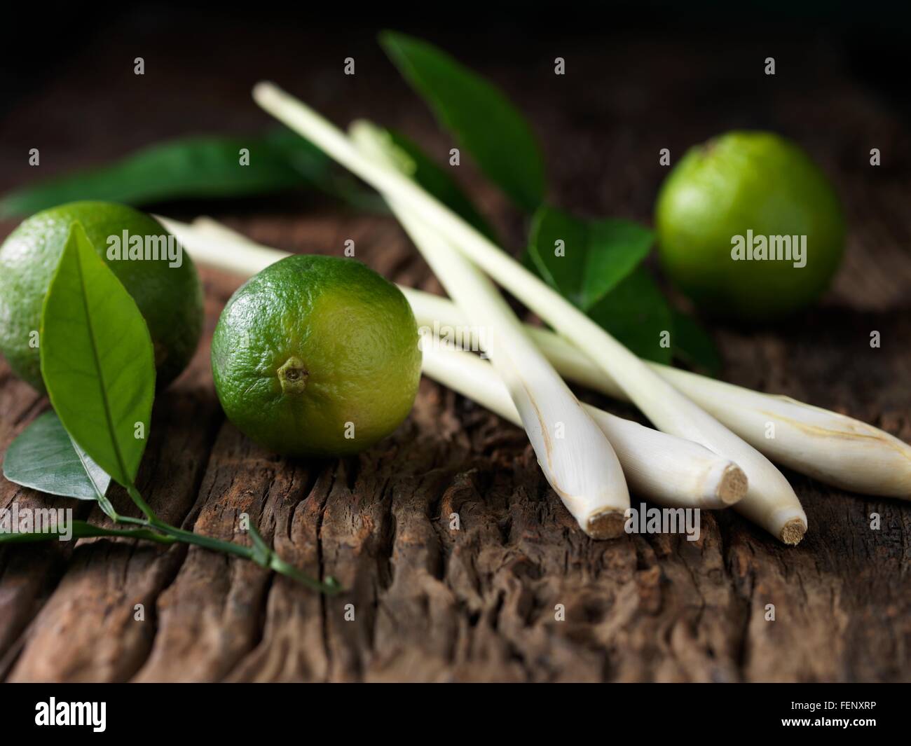 I tigli e lemon grass su ruvida la superficie di legno Foto Stock