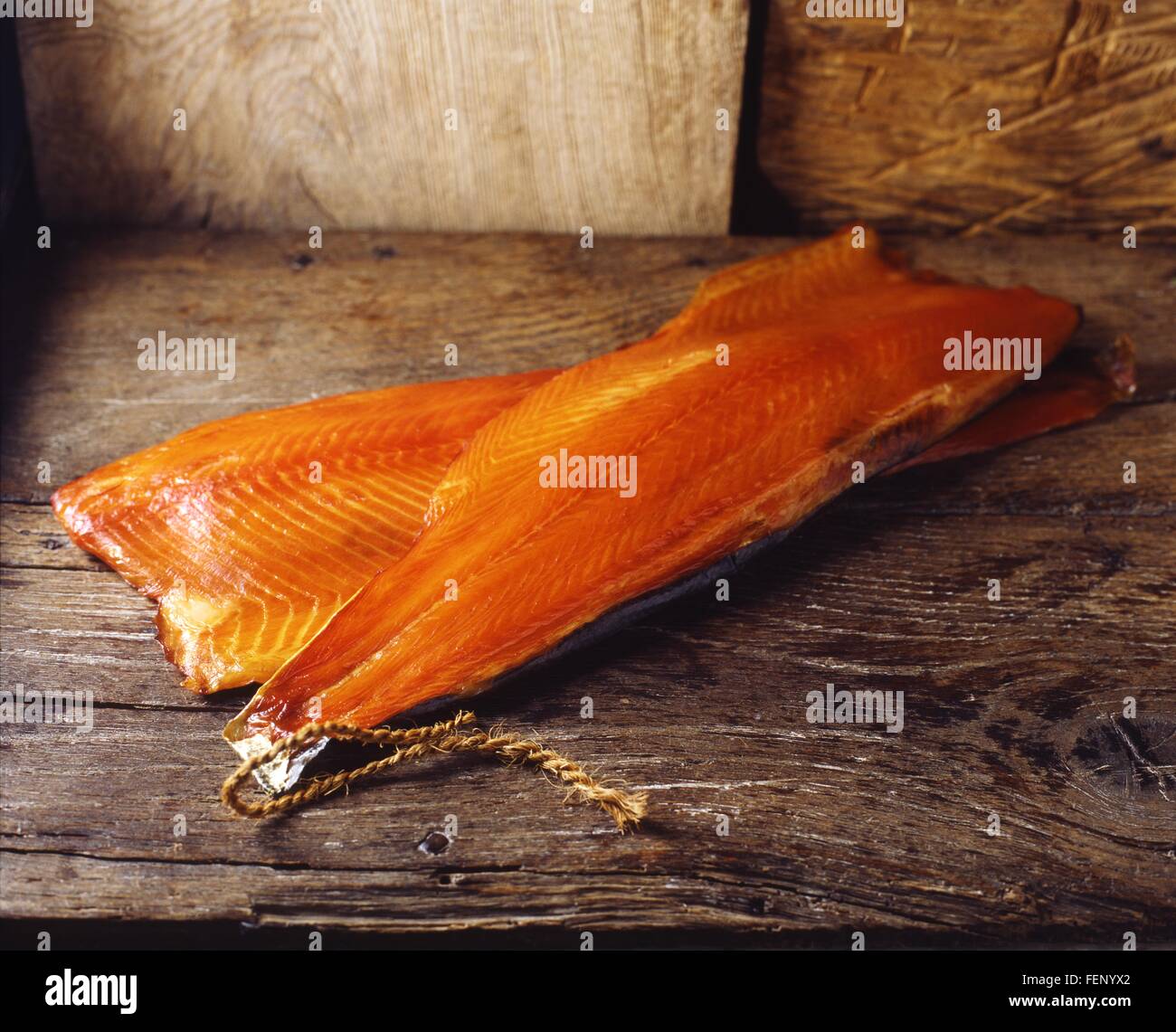 Materie salmone affumicato con la pelle su tavola in legno rustico Foto Stock