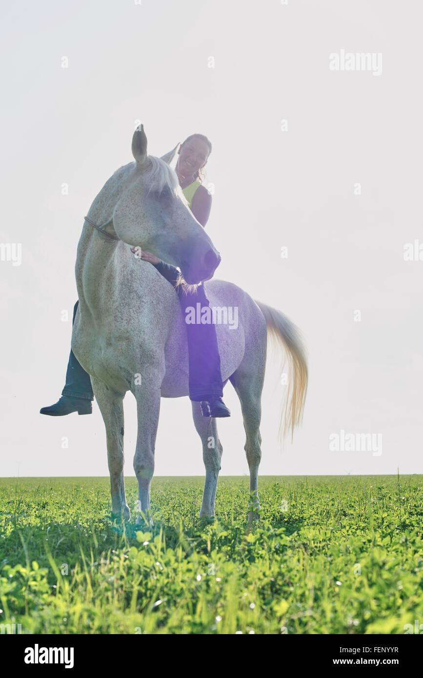 Ritratto di donna di equitazione bareback nel campo Foto Stock