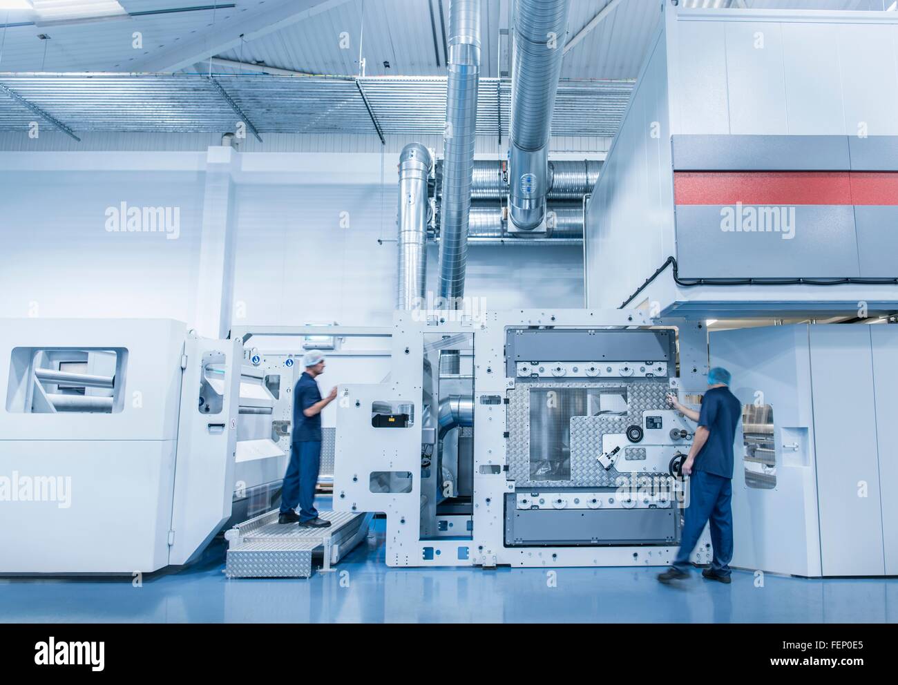 I lavoratori di funzionamento della macchina di stampa nel confezionamento alimentare fabbrica di stampa Foto Stock