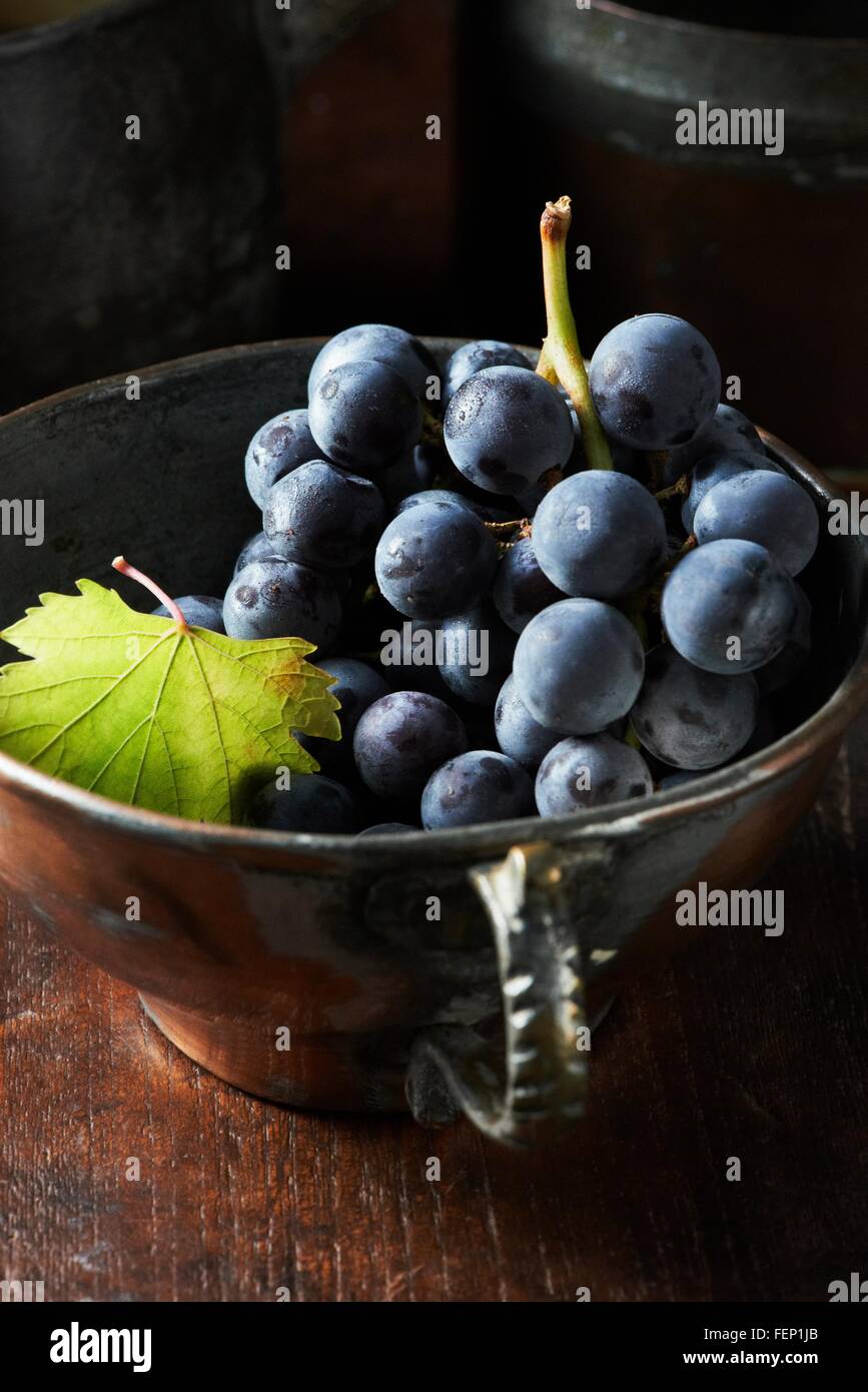 Elevato angolo di visione del grappolo di uva nera nel vintage tazzina Foto Stock