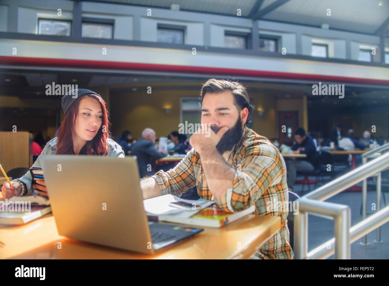 Due adulti college gli studenti che lavorano su laptop al banco in aula Foto Stock