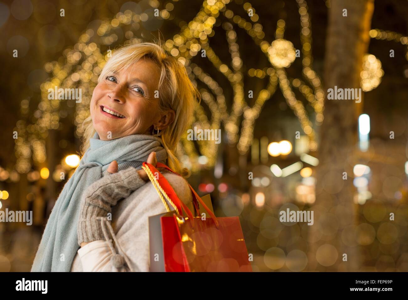 Ritratto di donna matura con xmas shopping sul viale alberato, Maiorca, SPAGNA Foto Stock