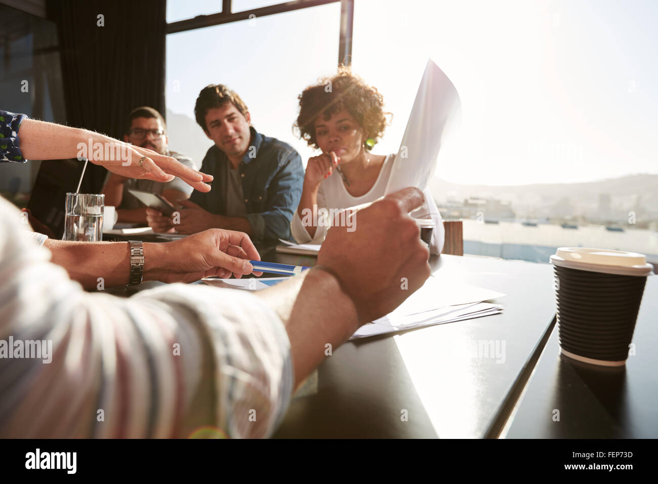 Le mani del giovane uomo e donna spiegando business plan ai colleghi, team creativo avente una riunione in ufficio. La messa a fuoco a portata di mano e Foto Stock