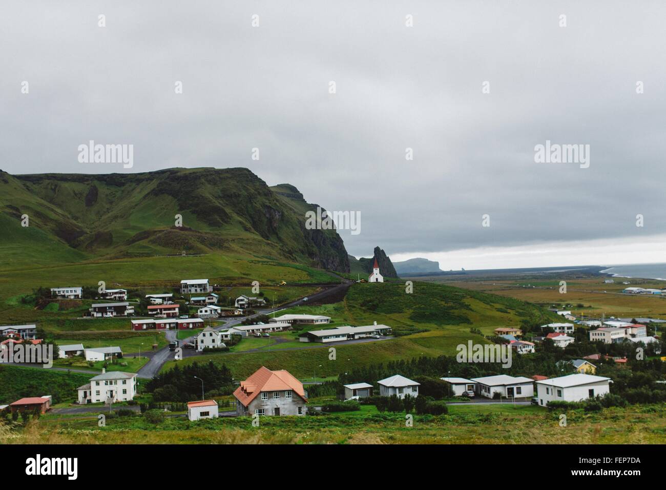 Angolo di alta vista del villaggio costiero di verde e rigogliosa montagna, Vik, Islanda Foto Stock
