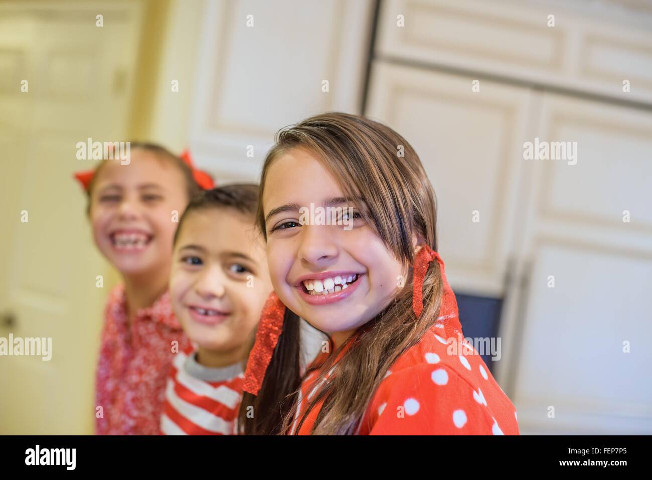 Angolo di visualizzazione dei bambini indossare pigiami guardando sorridente della fotocamera Foto Stock