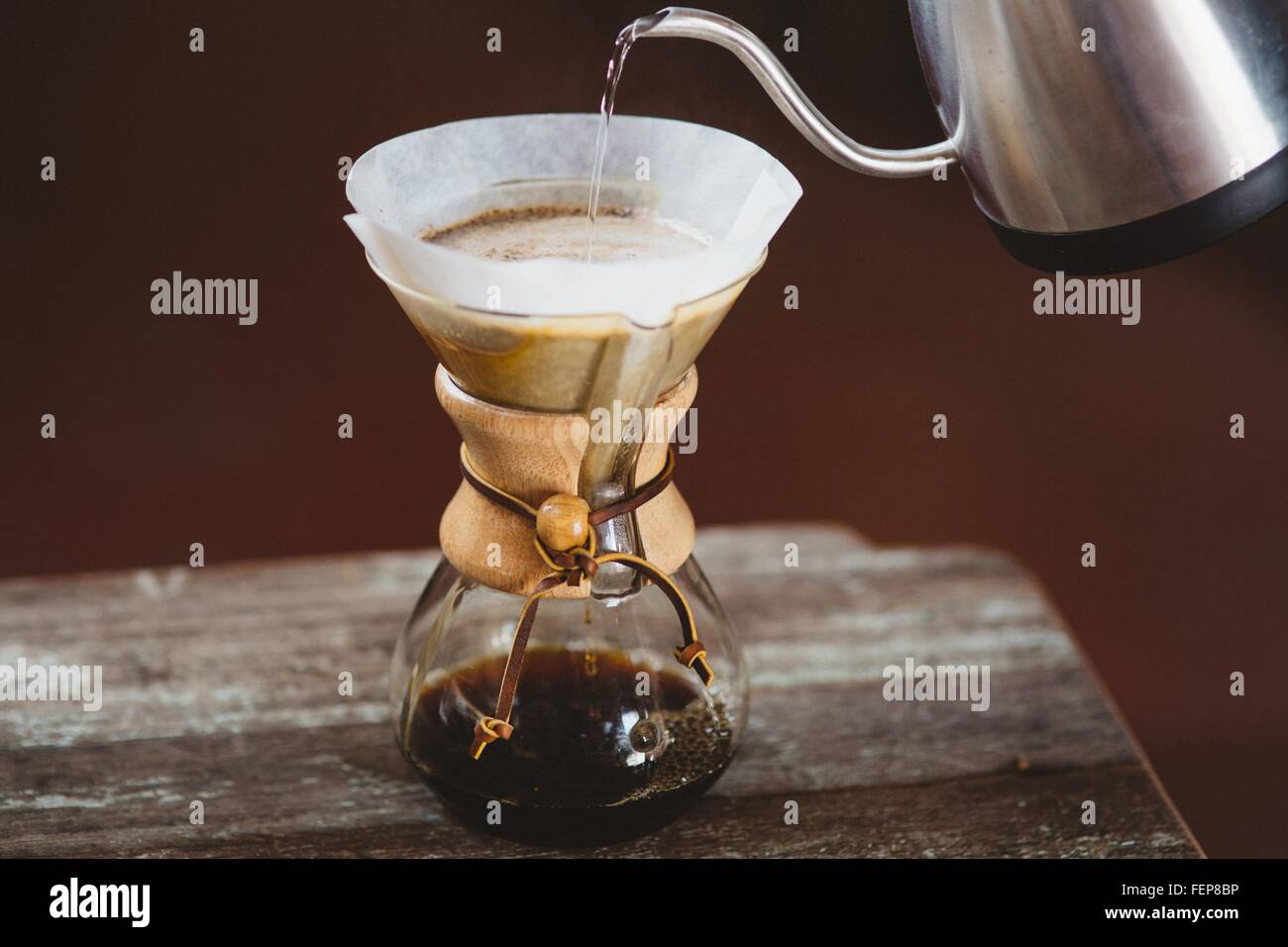 Versare acqua nel filtro macchina per il caffè Foto Stock