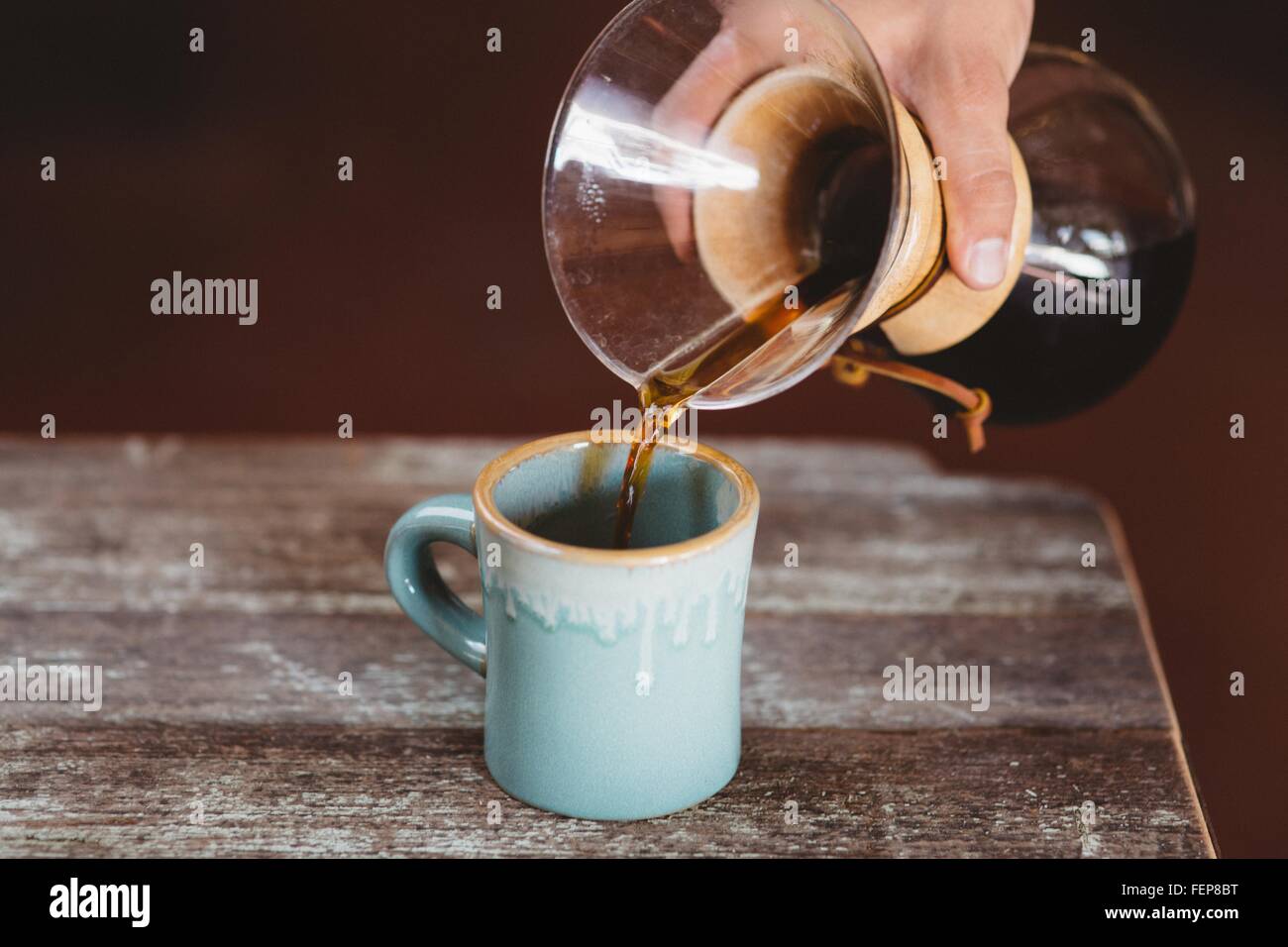 L'uomo versando il caffè dal filtro caffettiera Foto Stock