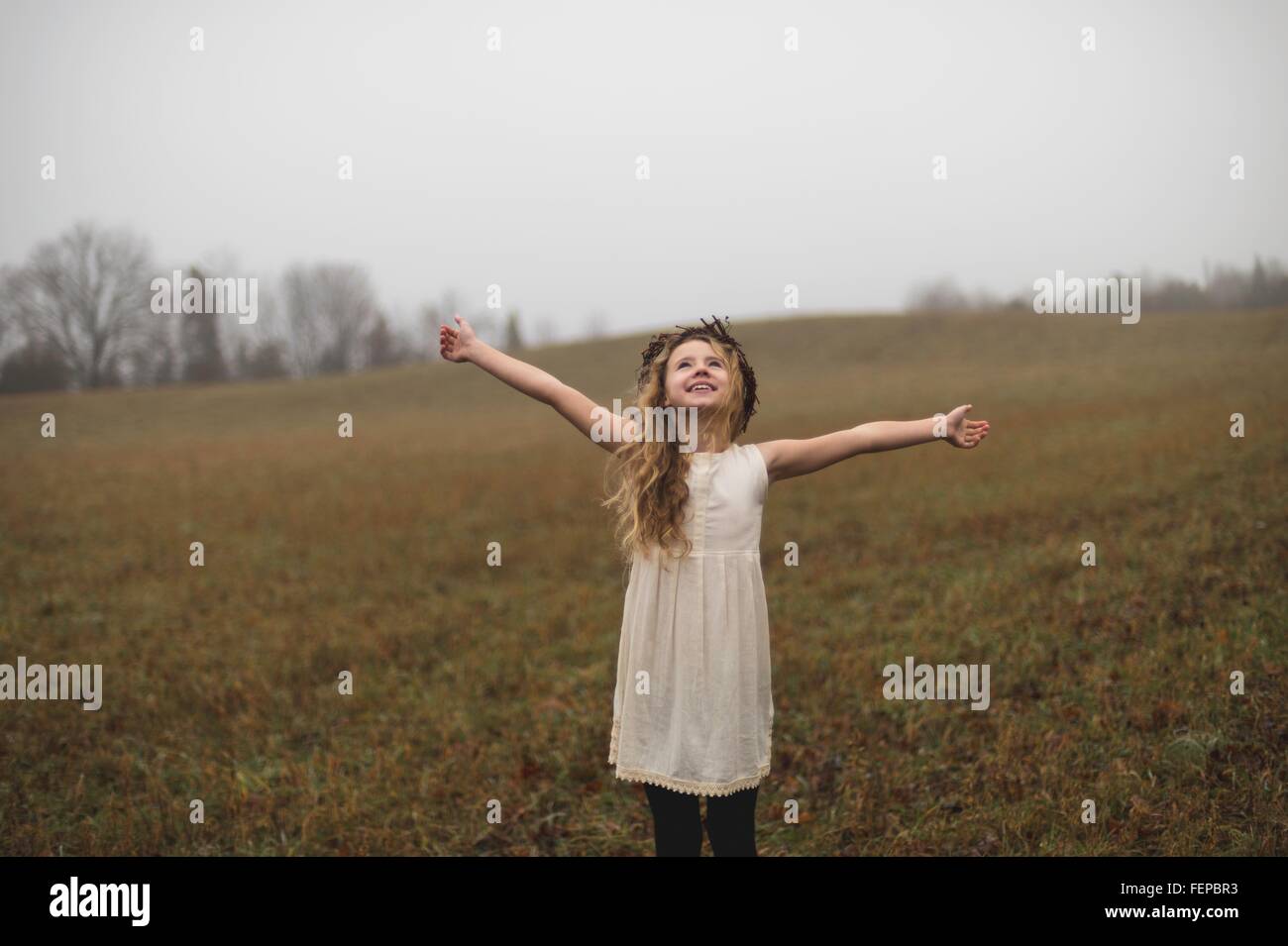 Ritratto di lunghi capelli biondi ragazza con le braccia aperte nel campo Foto Stock