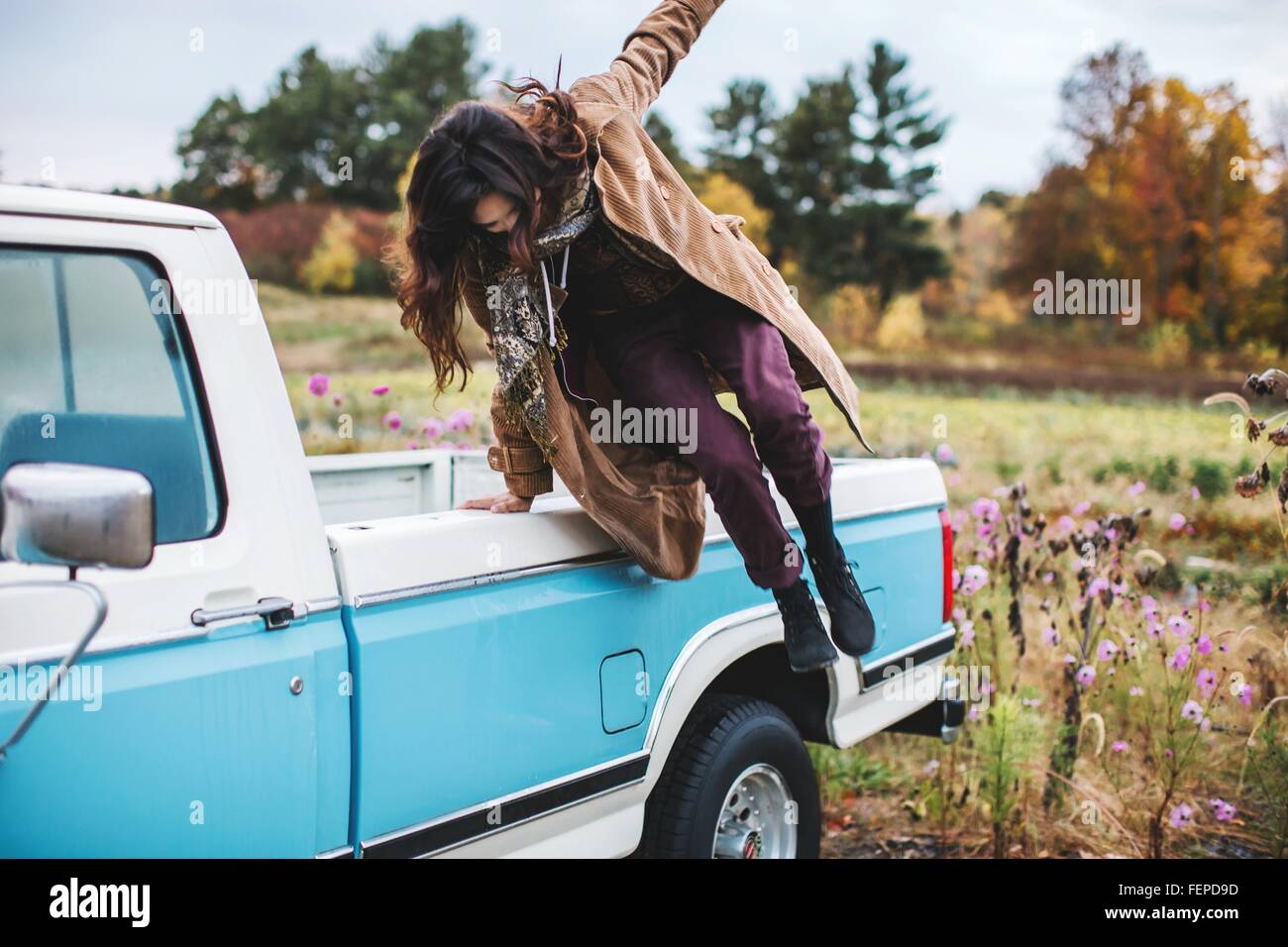 Giovane donna jumping dal retro del carrello Foto Stock