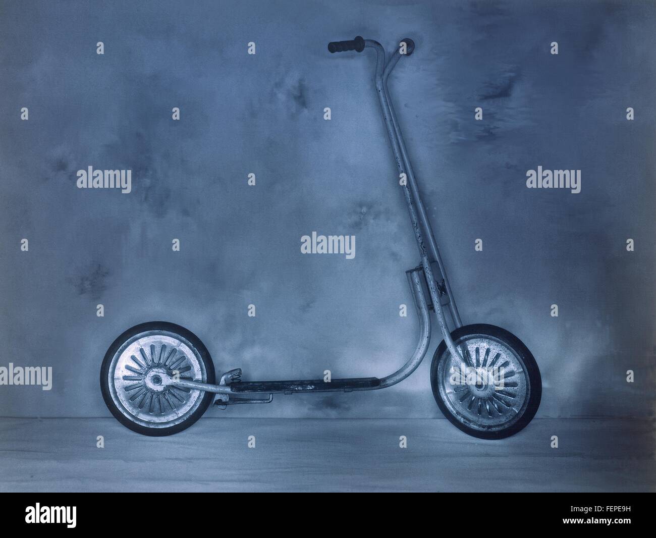 Vintage scooter blu appoggiata contro la parete Foto Stock