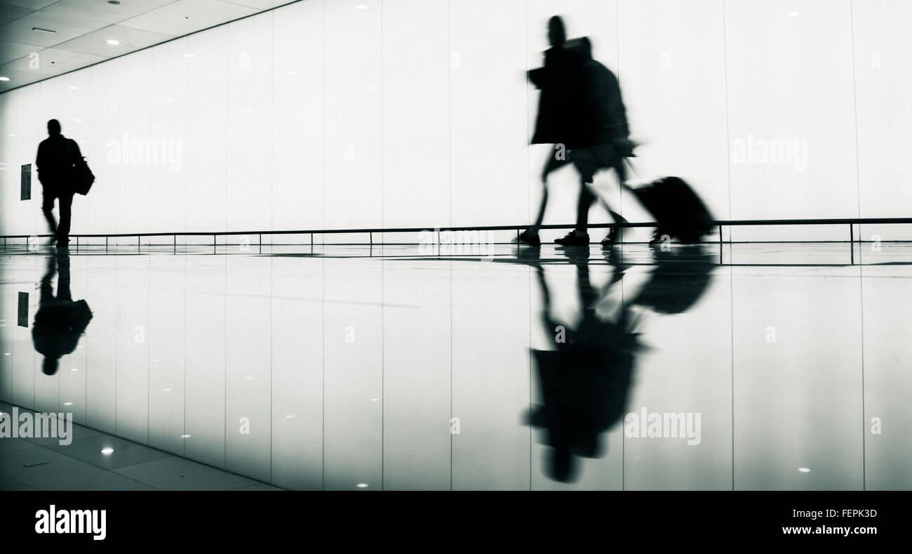 I passeggeri con bagaglio a mano aeroporto di avvicinamento alle porte di protezione. Foto Stock