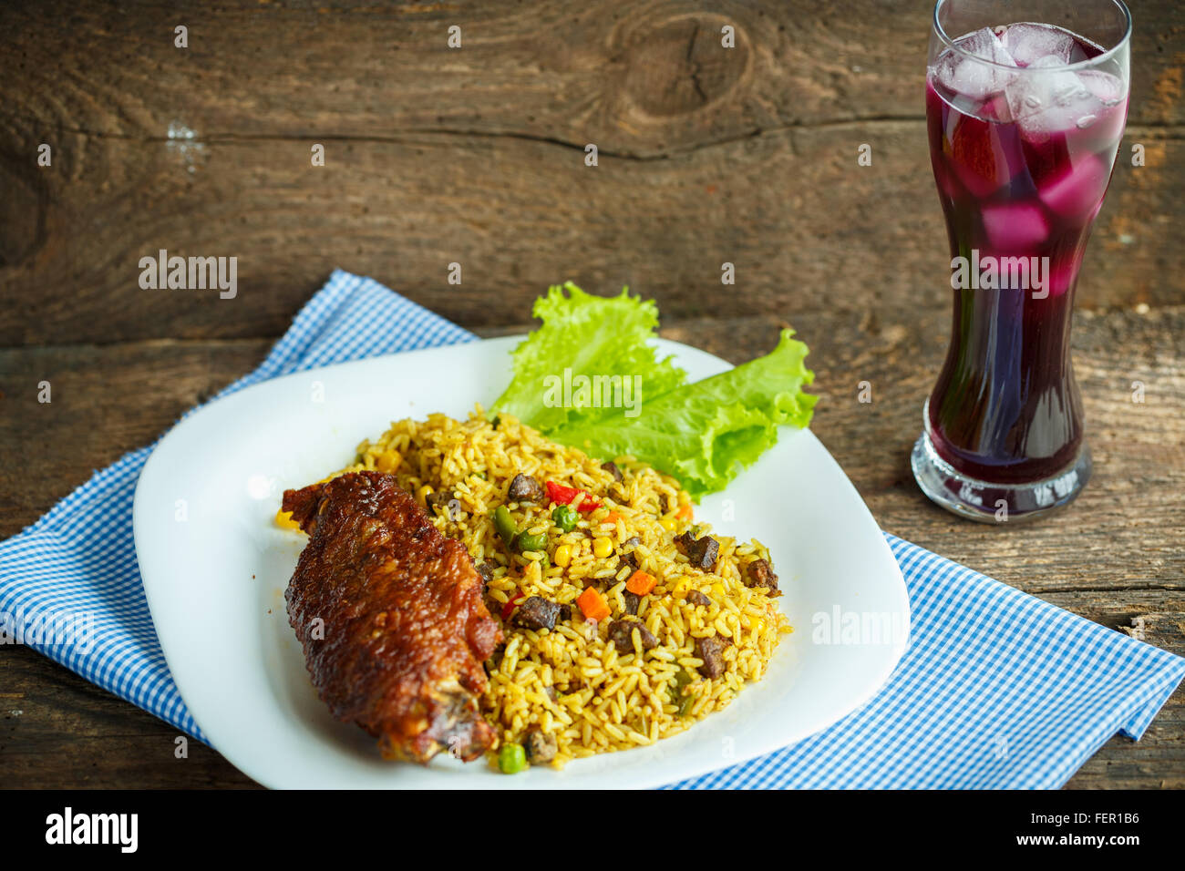 Deliziosi piatti di carne di tacchino con riso e foglie di insalata e un bicchiere di succo di frutta con ghiaccio Foto Stock