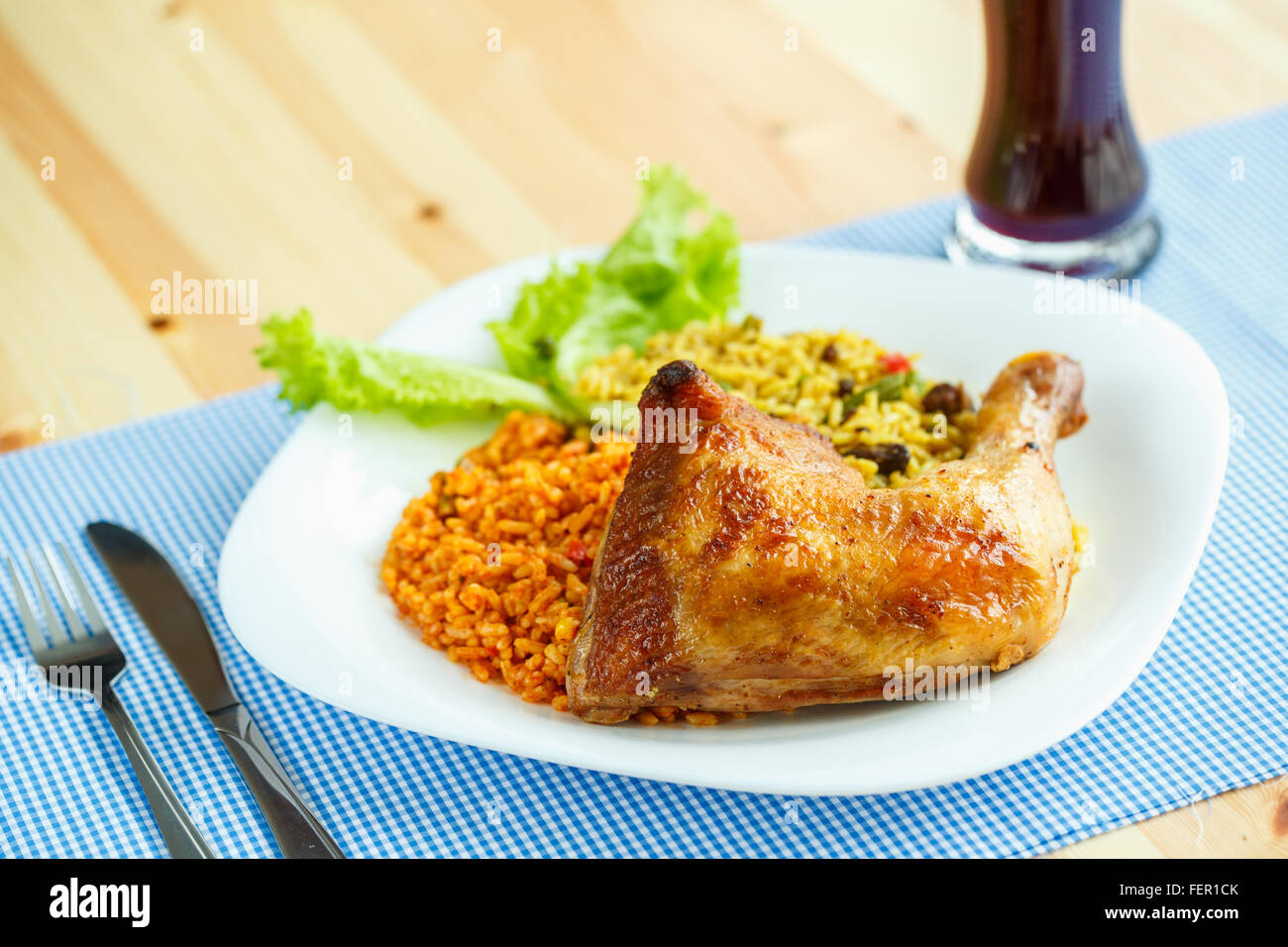 Gustoso piatto di coscia di pollo con riso e foglie di insalata Foto Stock