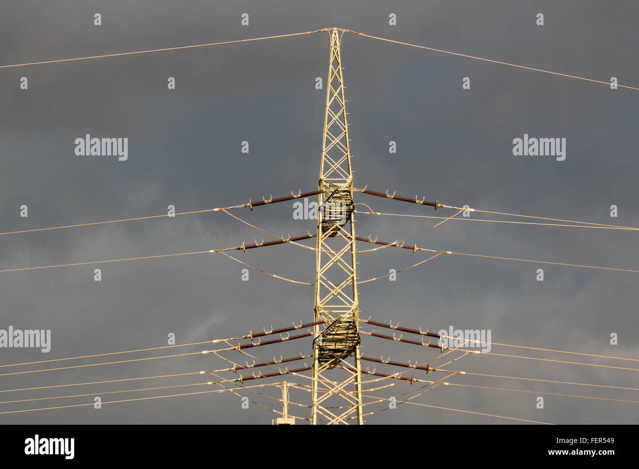 Di elettricità ad alta tensione tralicci contro il cielo blu con nuvole di pioggia Foto Stock