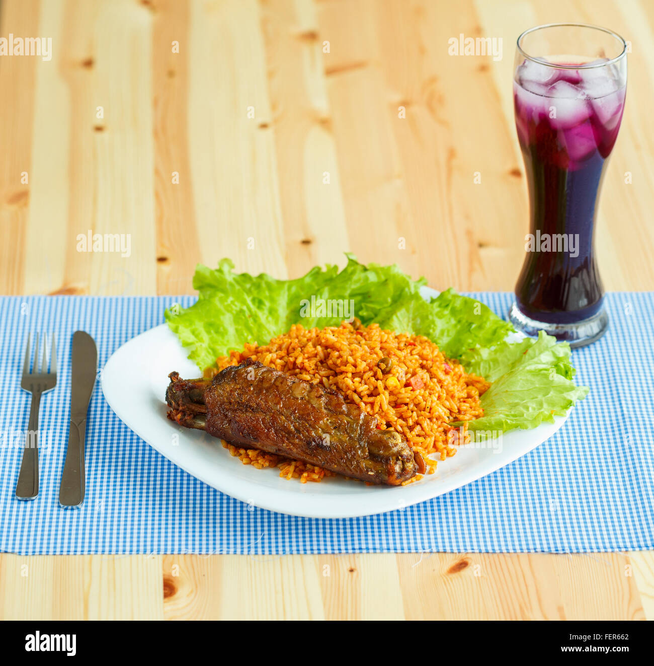 Deliziosi piatti di carne di tacchino con riso e foglie di insalata e un bicchiere di succo di frutta con ghiaccio Foto Stock
