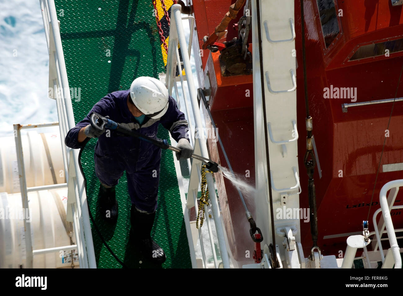 Contenitore nave membro di equipaggio attrezzature i tubi flessibili sul ponte Foto Stock