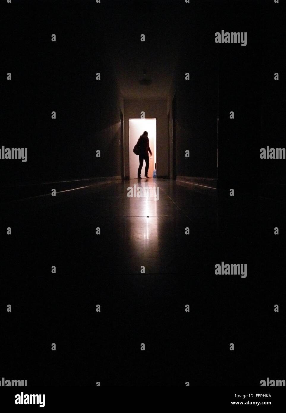 Silhouette persona nel corridoio entrando in camera illuminata Foto Stock