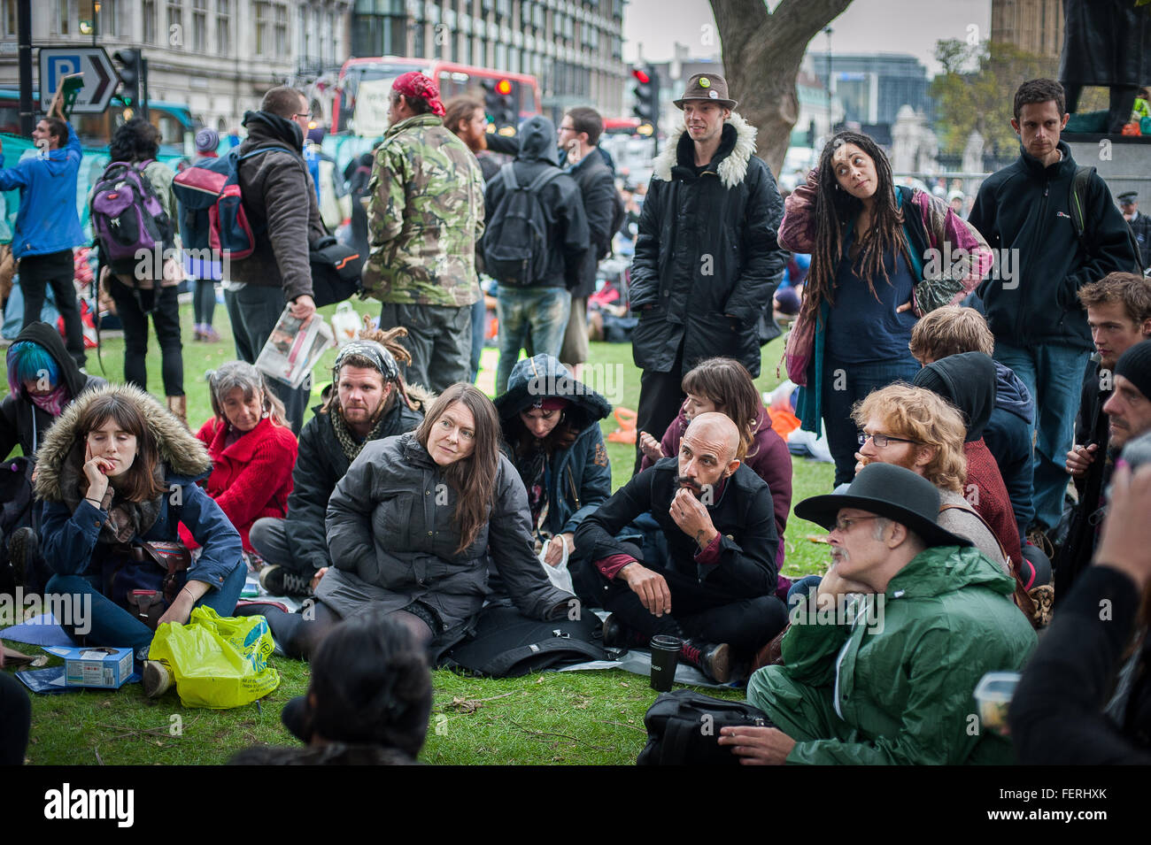 Gli attivisti attento ascolto di un discorso a occupare la piazza del Parlamento, Londra Foto Stock