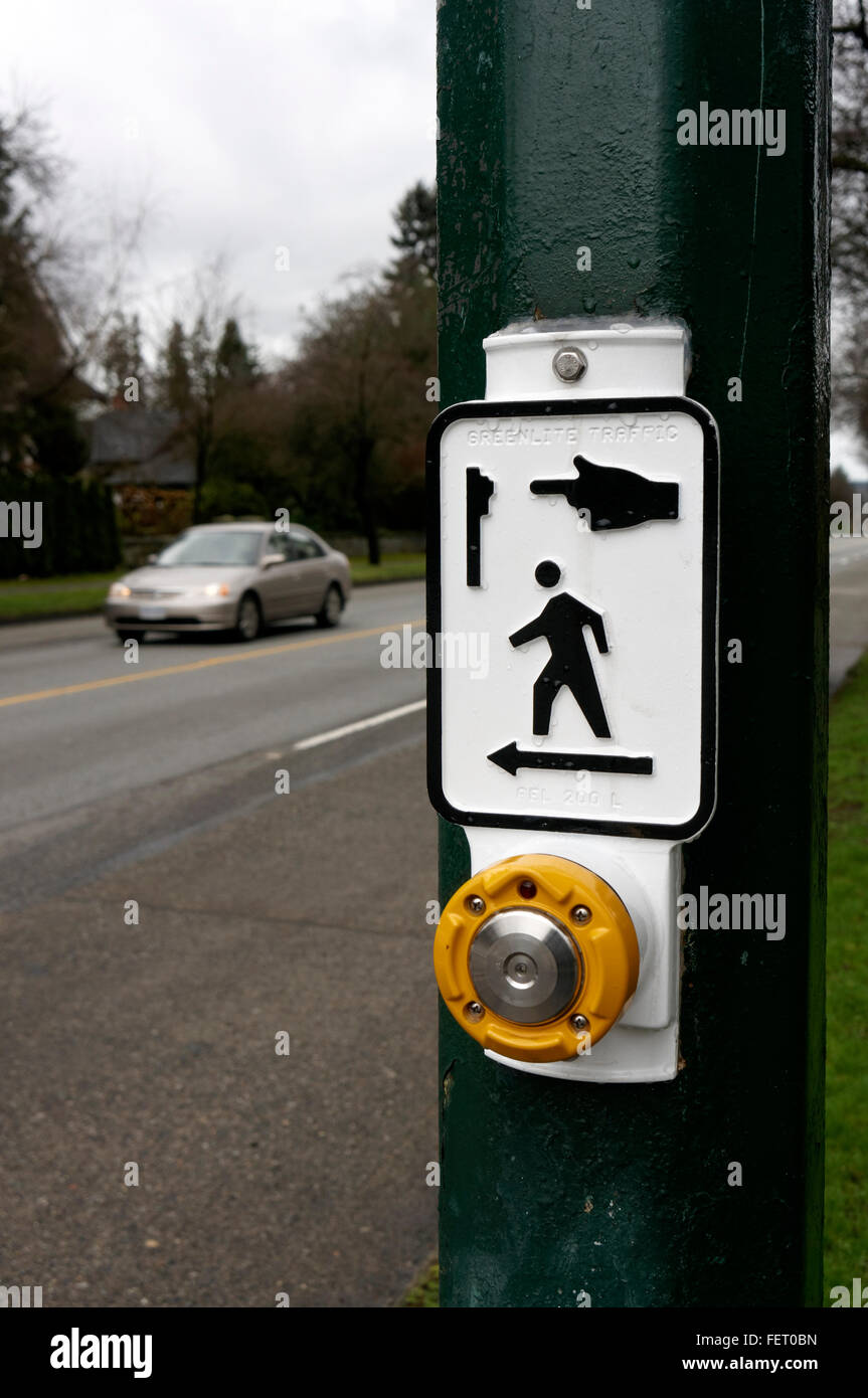 Crosswalk pedonale pulsante del segnale con street e auto in background, Vancouver, BC, Canada Foto Stock