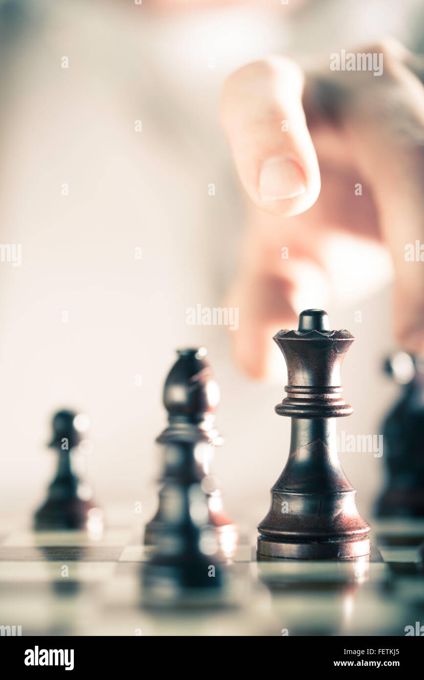 L'immagine verticale di un gioco di scacchi con focus sulla regina e sfocata a mano sullo sfondo, copia dello spazio sul lato sinistro. Concetto Foto Stock
