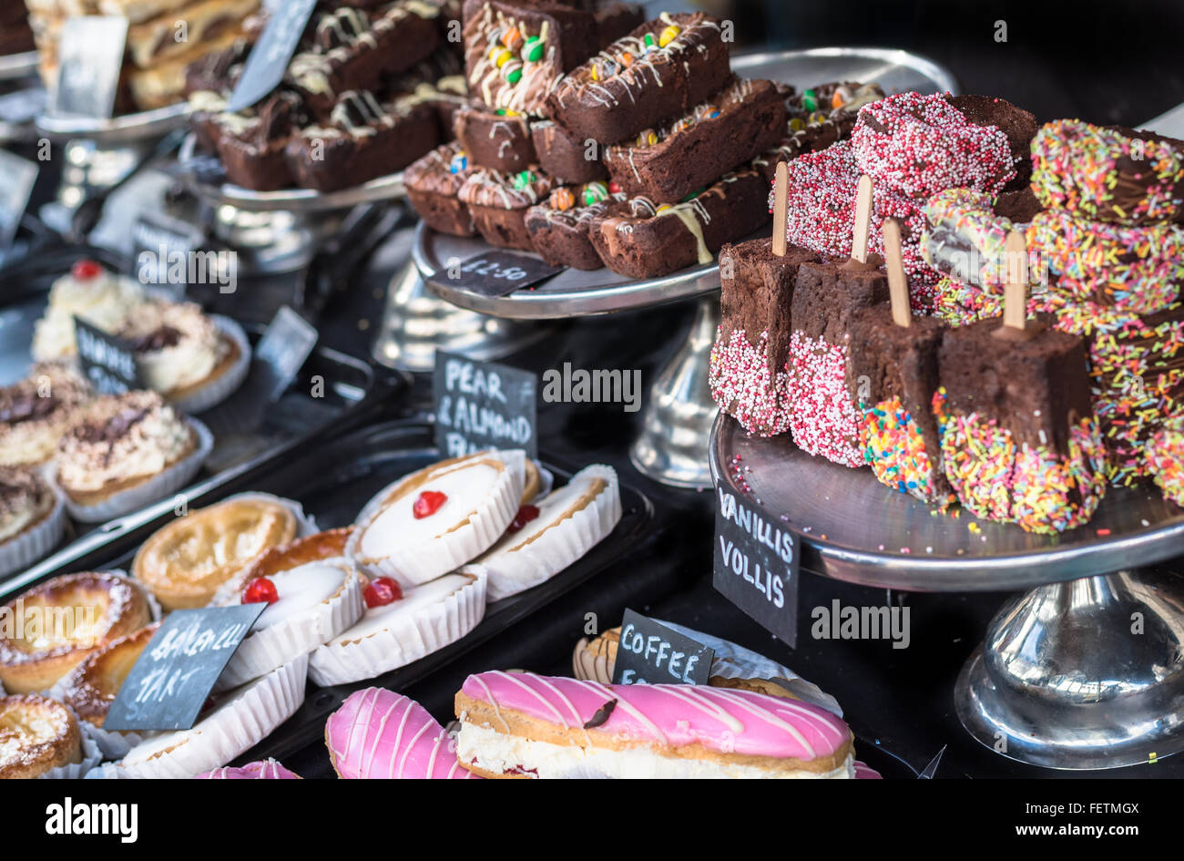 Una varietà di torte e brownie al cioccolato sul display in un negozio. Foto Stock