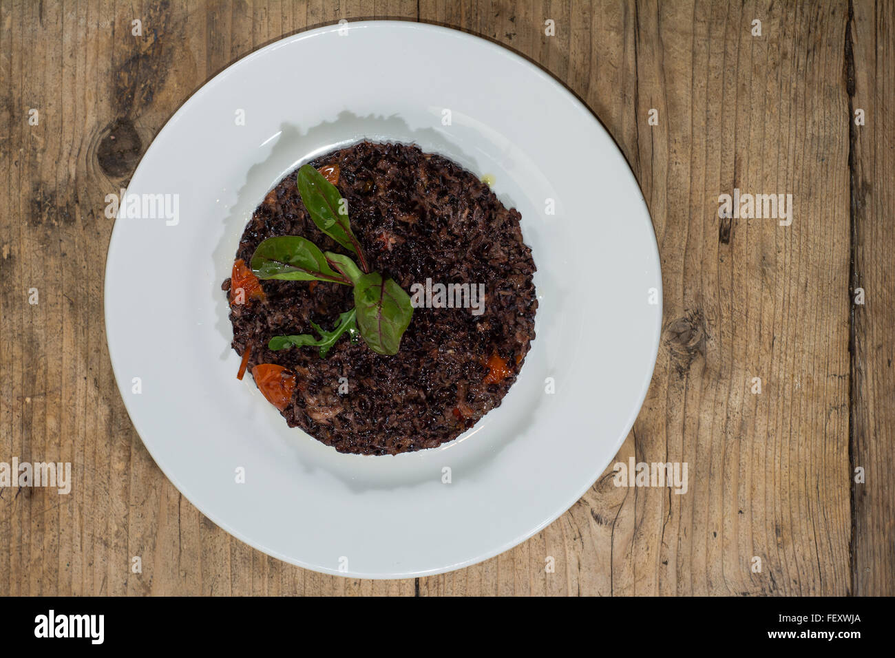 Il granchio risotto con il riso nero. Il granchio e naturalmente il riso nero (noto anche come proibiti riso) con peperoncino e pomodoro ciliegino Foto Stock