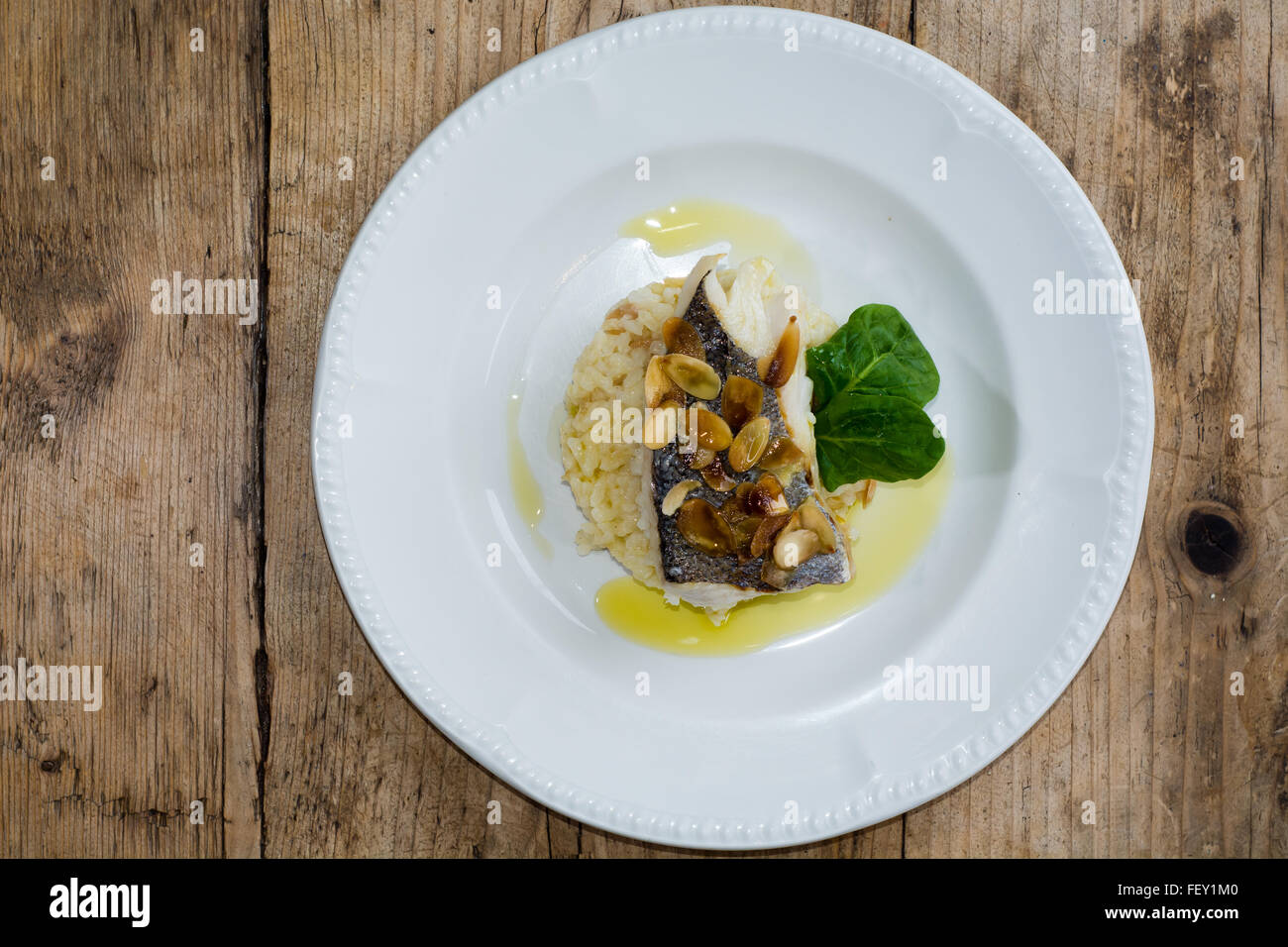 Nasello e mandorla risotto. Filetto di nasello su un letto di mandorle, limone e olio di oliva risotto: Risotto de Merlu Foto Stock