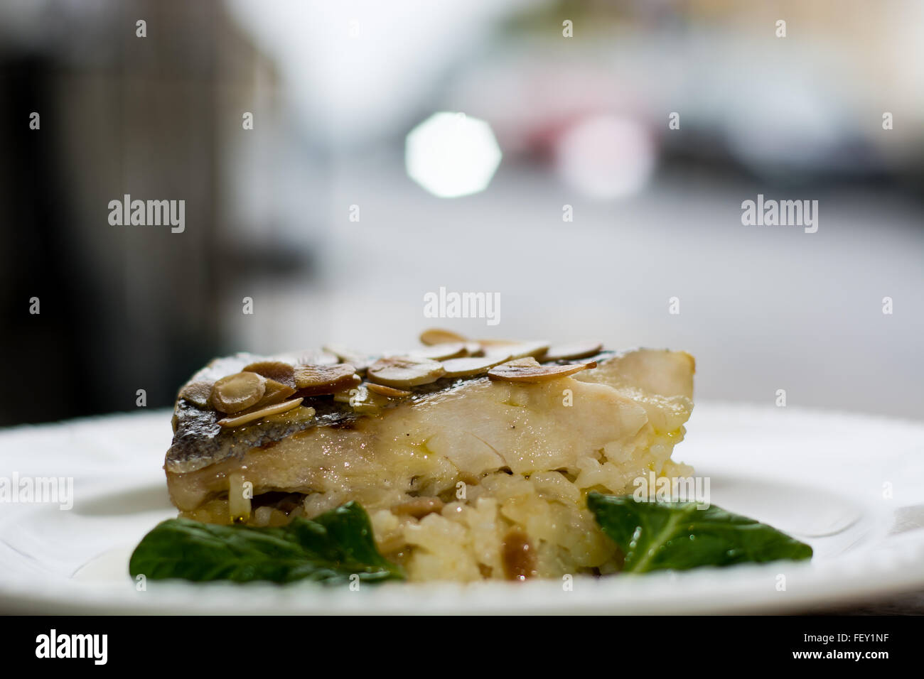 Nasello e mandorla risotto. Filetto di nasello su un letto di mandorle, limone e olio di oliva risotto: Risotto de Merlu Foto Stock