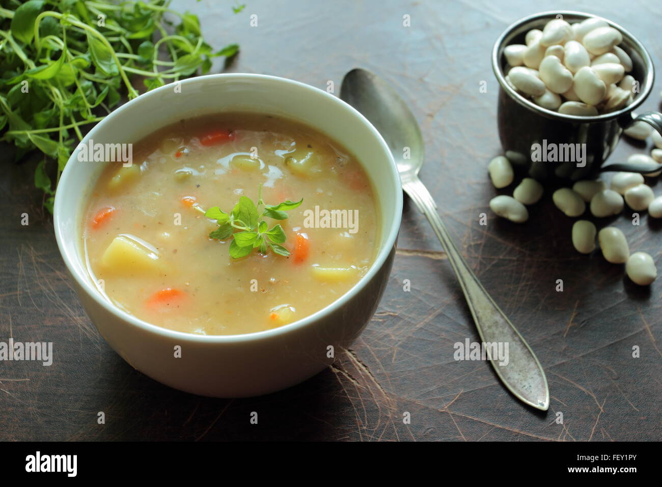 Ciotola con zuppa di fagioli e cucchiaio in metallo Foto Stock