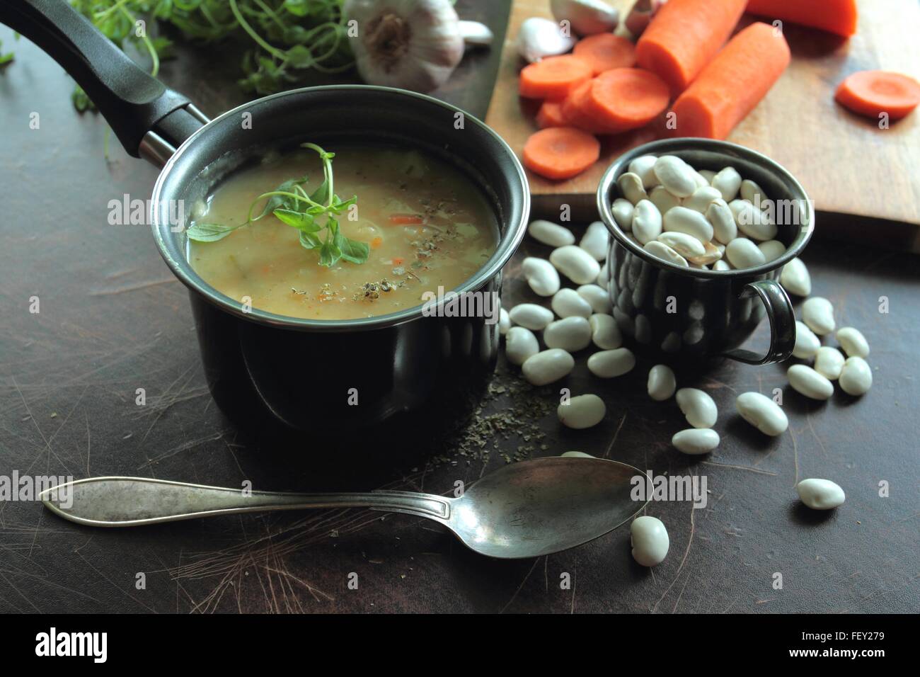 Piccola pentola con la zuppa di fagioli e erbe fresche Foto Stock
