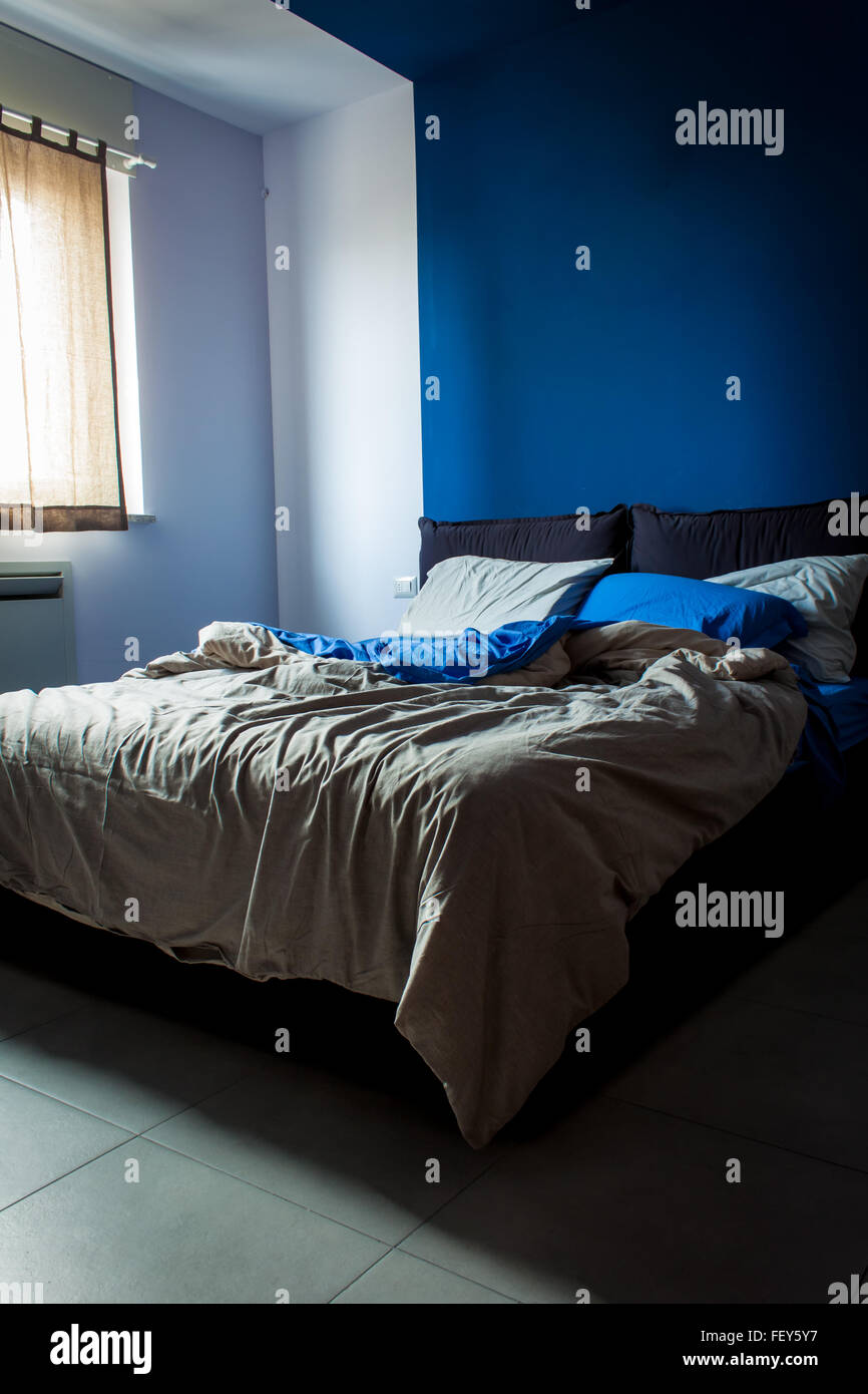Pulite e ordinate in camera da letto, le lenzuola di luce, il colore principale è il blu. Foto Stock