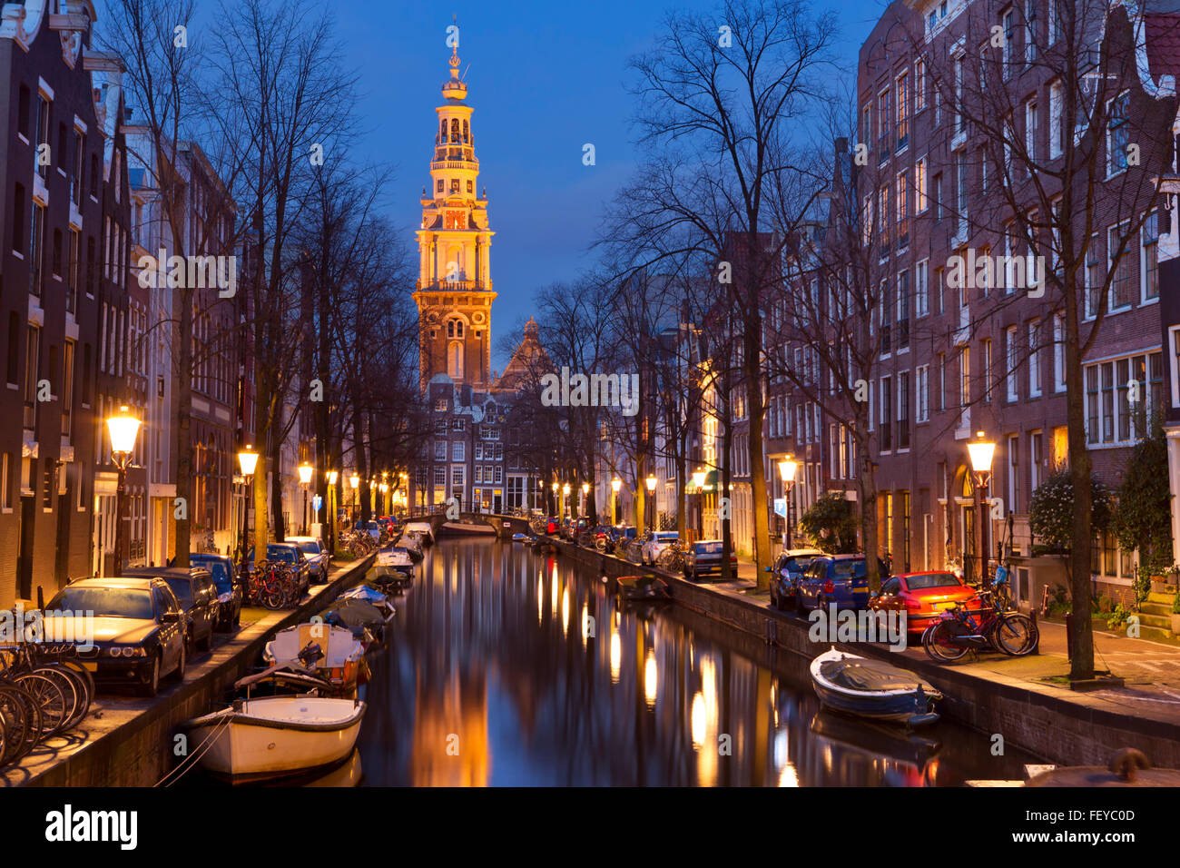 Torre di una chiesa alla fine di un canale nella città di Amsterdam, Paesi Bassi durante la notte. Foto Stock
