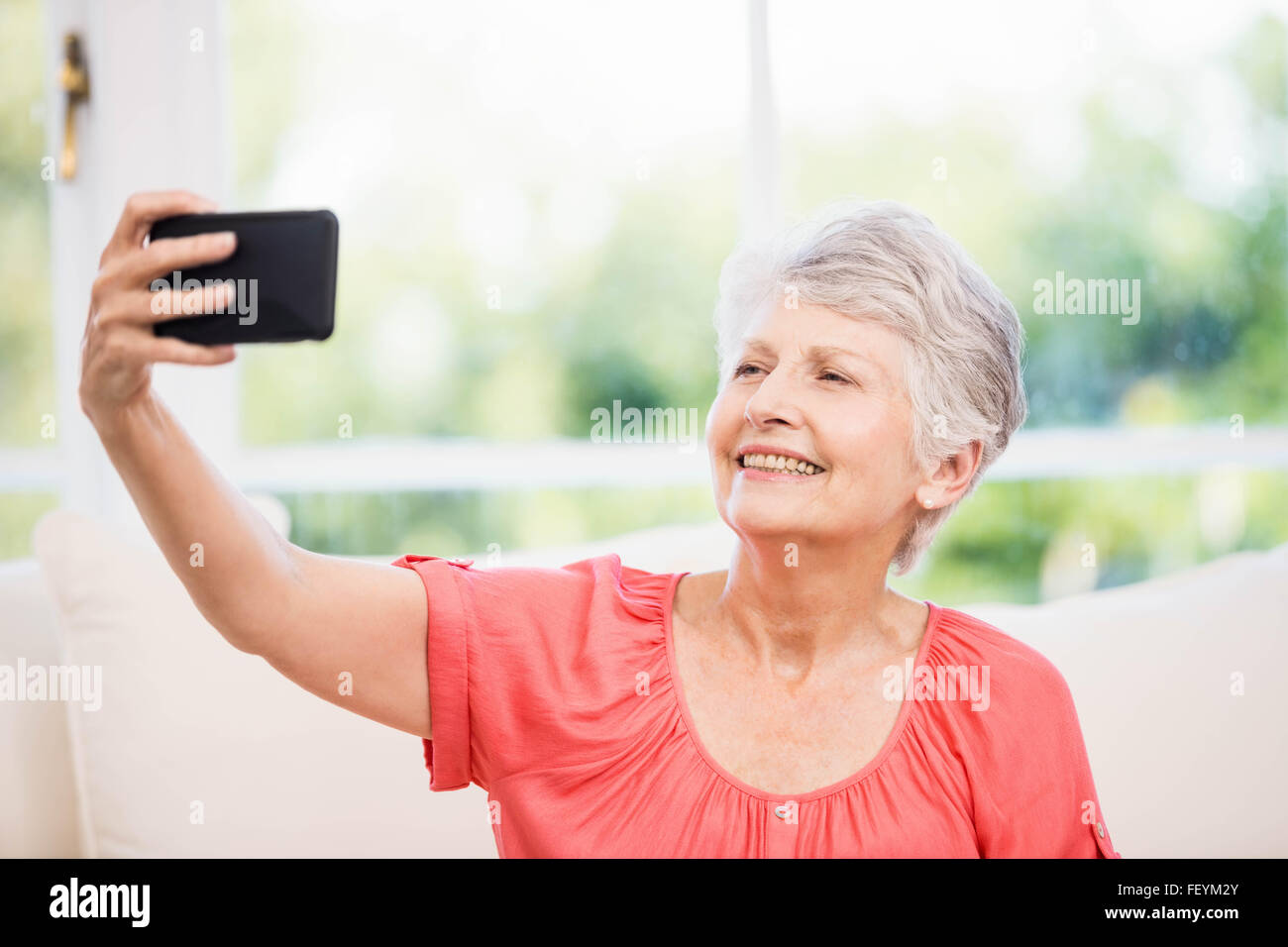 Felice senior donna prendendo selfie Foto Stock