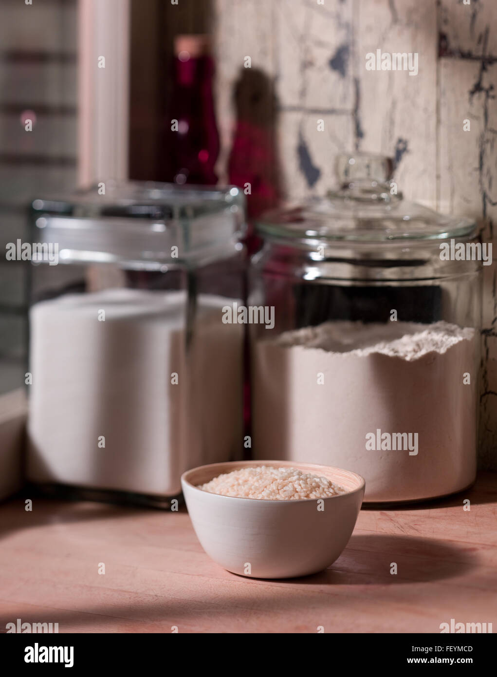 Ciotola di riso, zucchero e dei fiori sul banco di cucina. Foto Stock