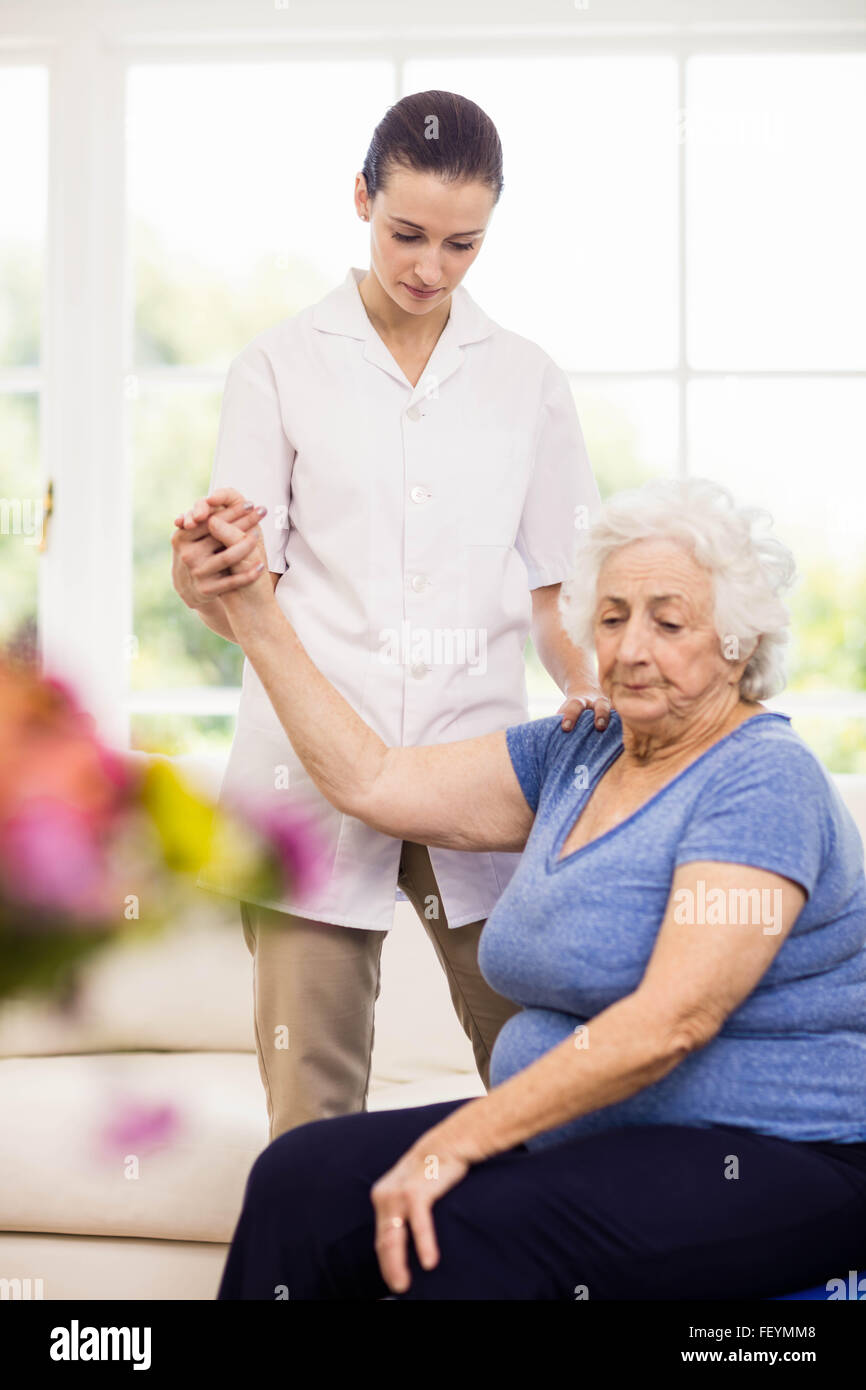 Fisioterapista prendersi cura dei malati anziani paziente Foto Stock