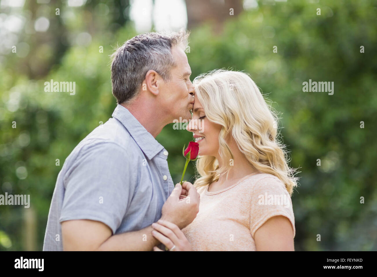 Il marito che offre una rosa alla moglie Foto Stock