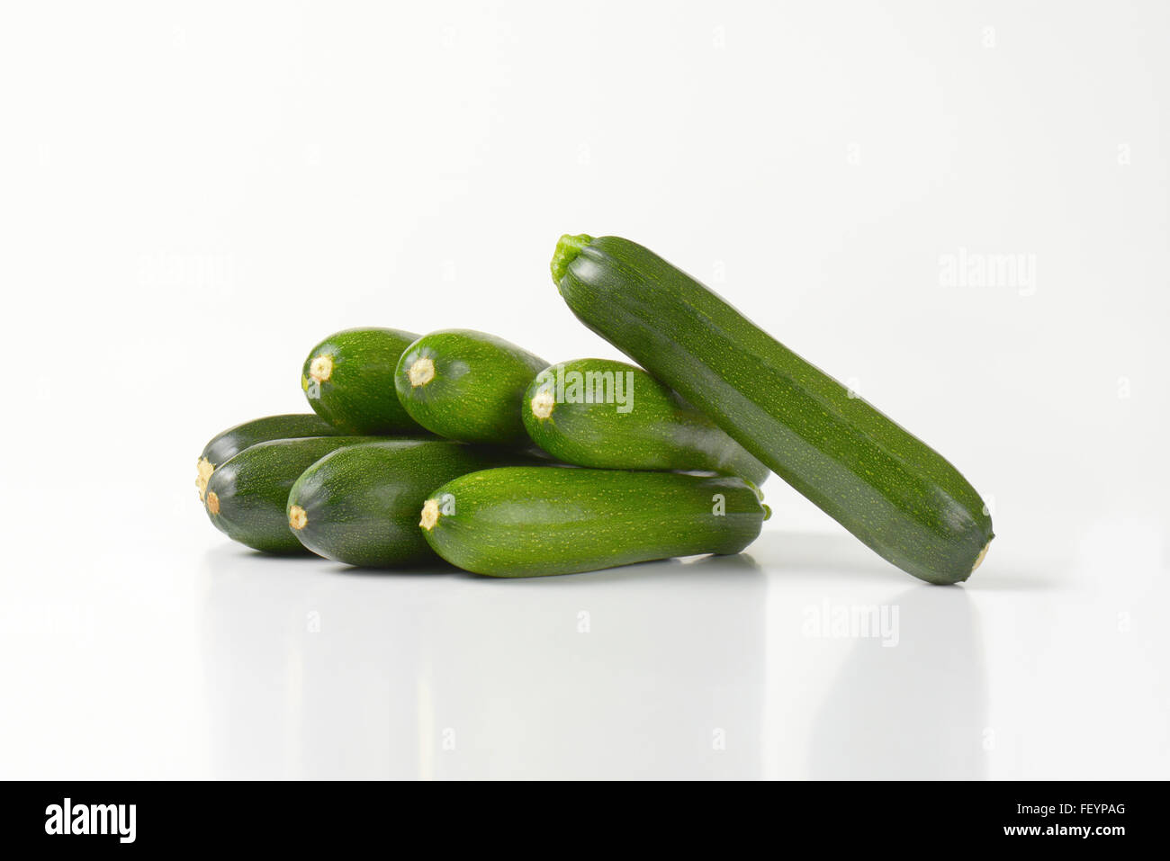 Pila di zucchine fresche su sfondo bianco Foto Stock