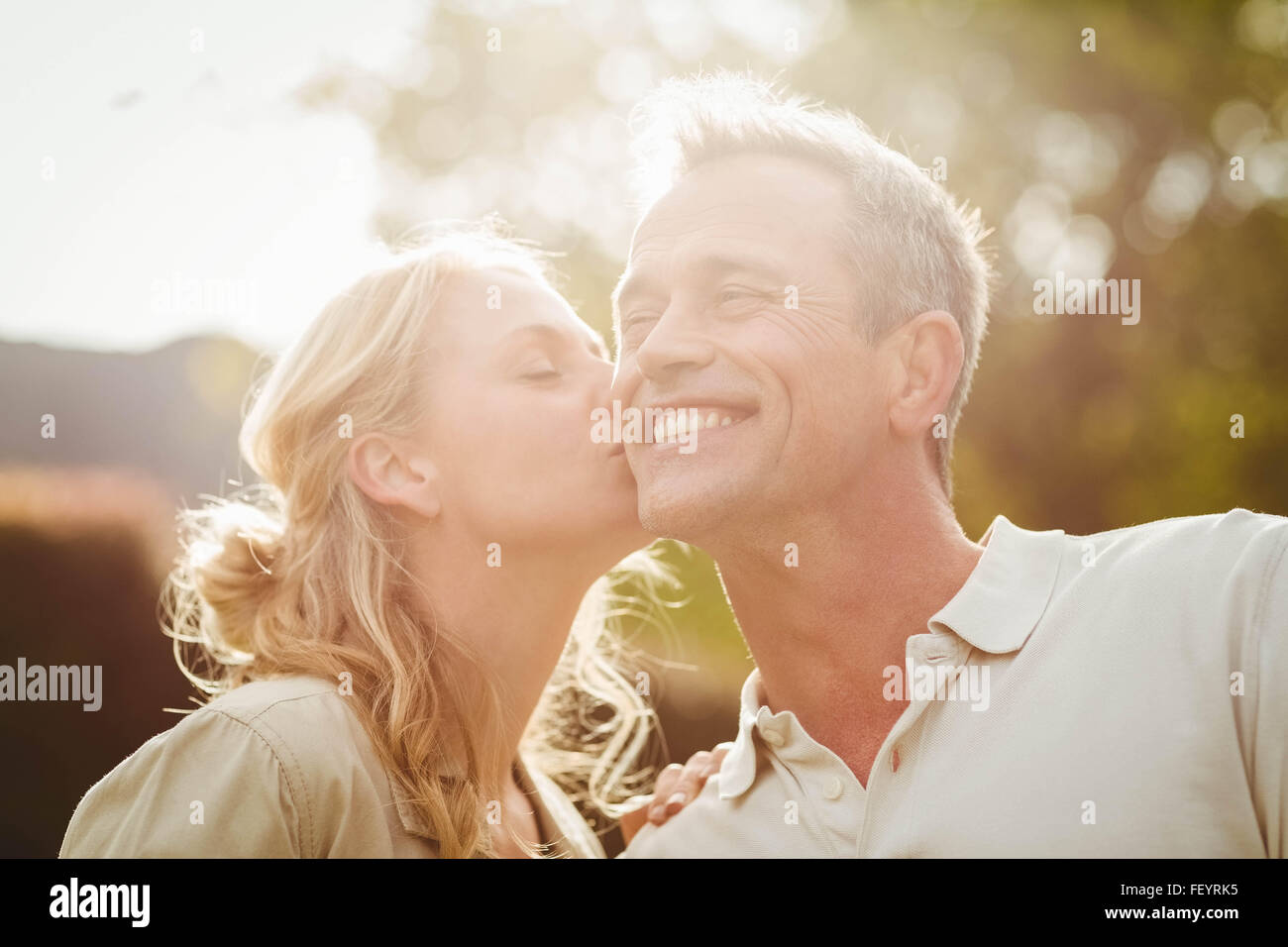 Moglie di baciare mio marito sulla guancia Foto Stock
