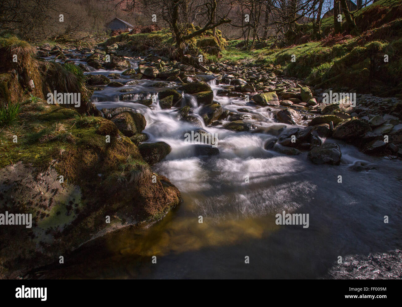 Afon Ystwyth, cascata fiume nella luce solare pezzata del Cambriano montagne al cambriano strada di montagna Foto Stock