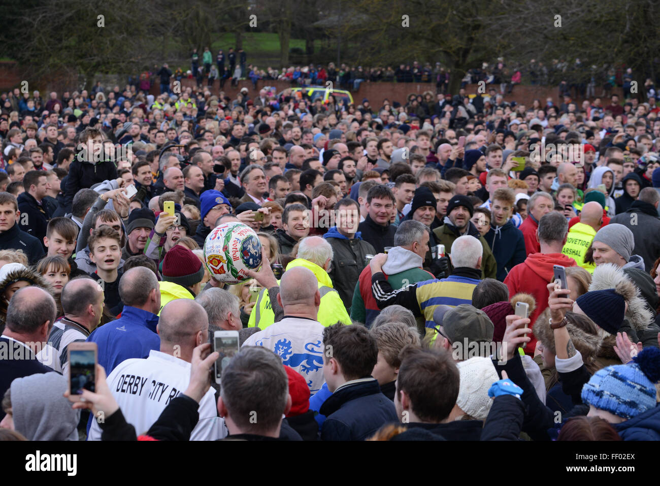 Ashbourne, Derbyshire, Regno Unito. Il 9 febbraio, 2016. Il dipinto a mano la sfera viene effettuata attraverso il folle prima di teh inizio della Shrovetide football. Gli obiettivi sono tre miglia di distanza e il gioco si svolge in due ore di otto periodi Martedì Grasso e il Mercoledì delle Ceneri. Credito: Nigel Spooner/Alamy Live News Foto Stock