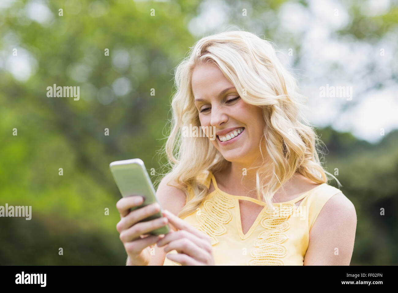 Donna felice utilizza lo smartphone Foto Stock