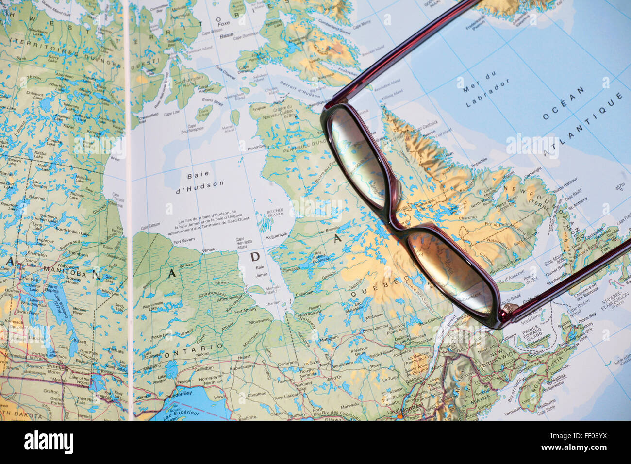 Bicchieri posa su un open atlante geografico prenota, close-up in Canada Foto Stock