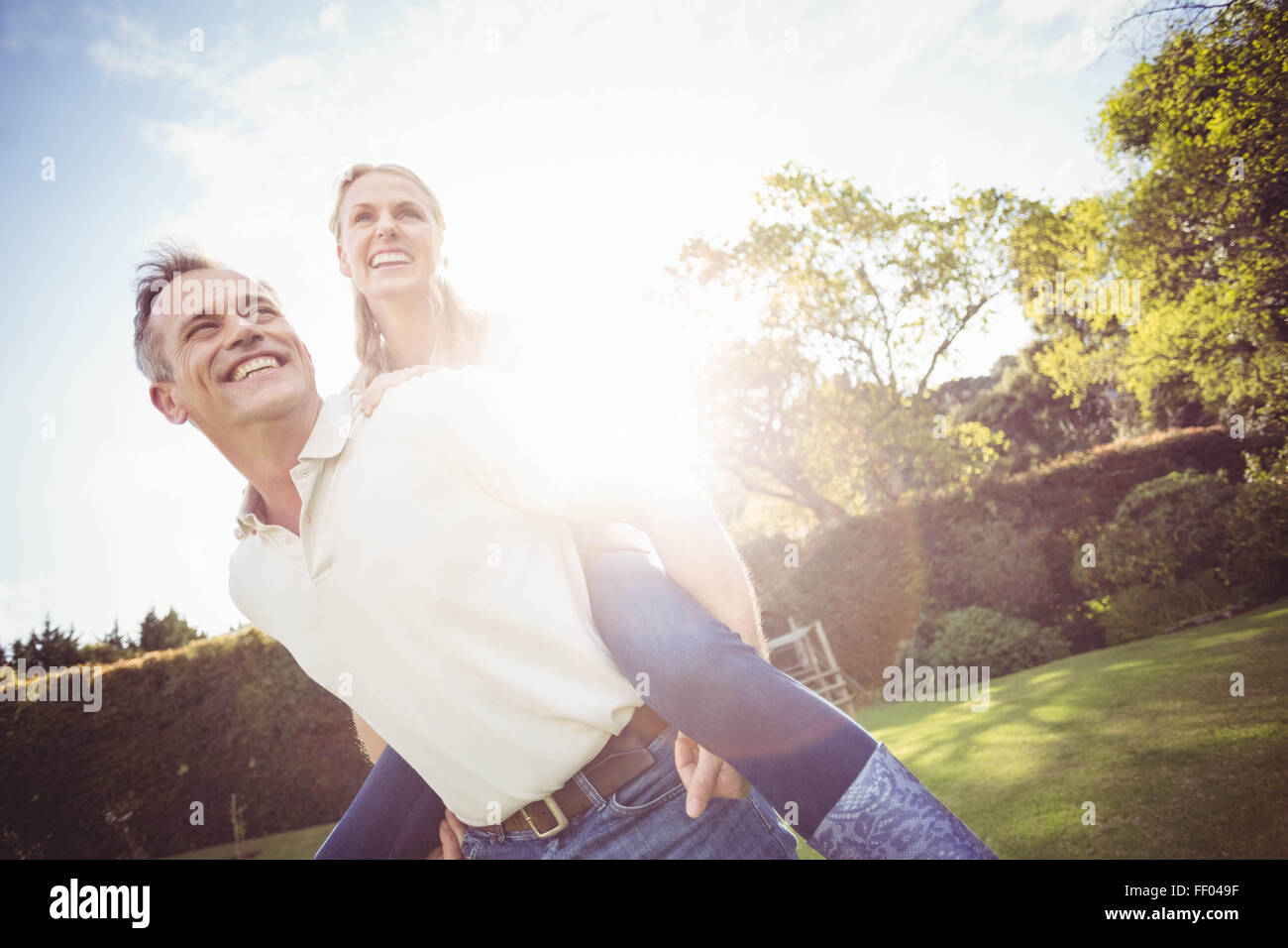 Il marito dando piggy back per moglie Foto Stock