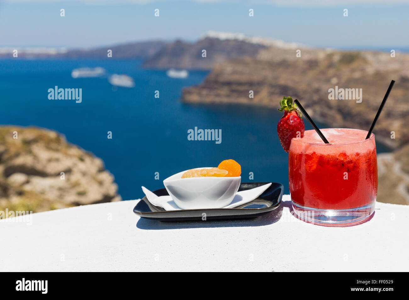 Vetro a freddo cocktail alla fragola e arancione sullo sfondo di un mare Bay Foto Stock