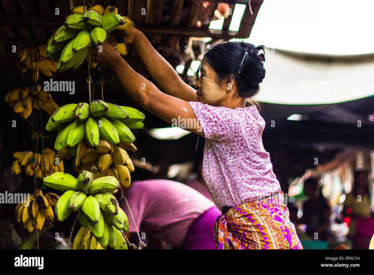 Donna taglio di banane di Nyaung U market Foto Stock
