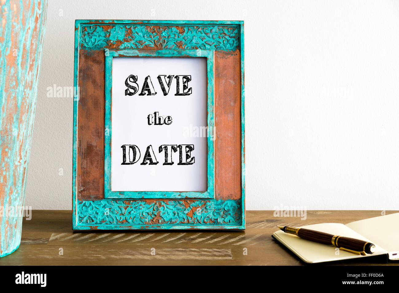 Vintage photo frame su un tavolo di legno oltre il muro bianco lo sfondo con il messaggio motivazionale SALVA LA DATA , copia spazio disponibile Foto Stock